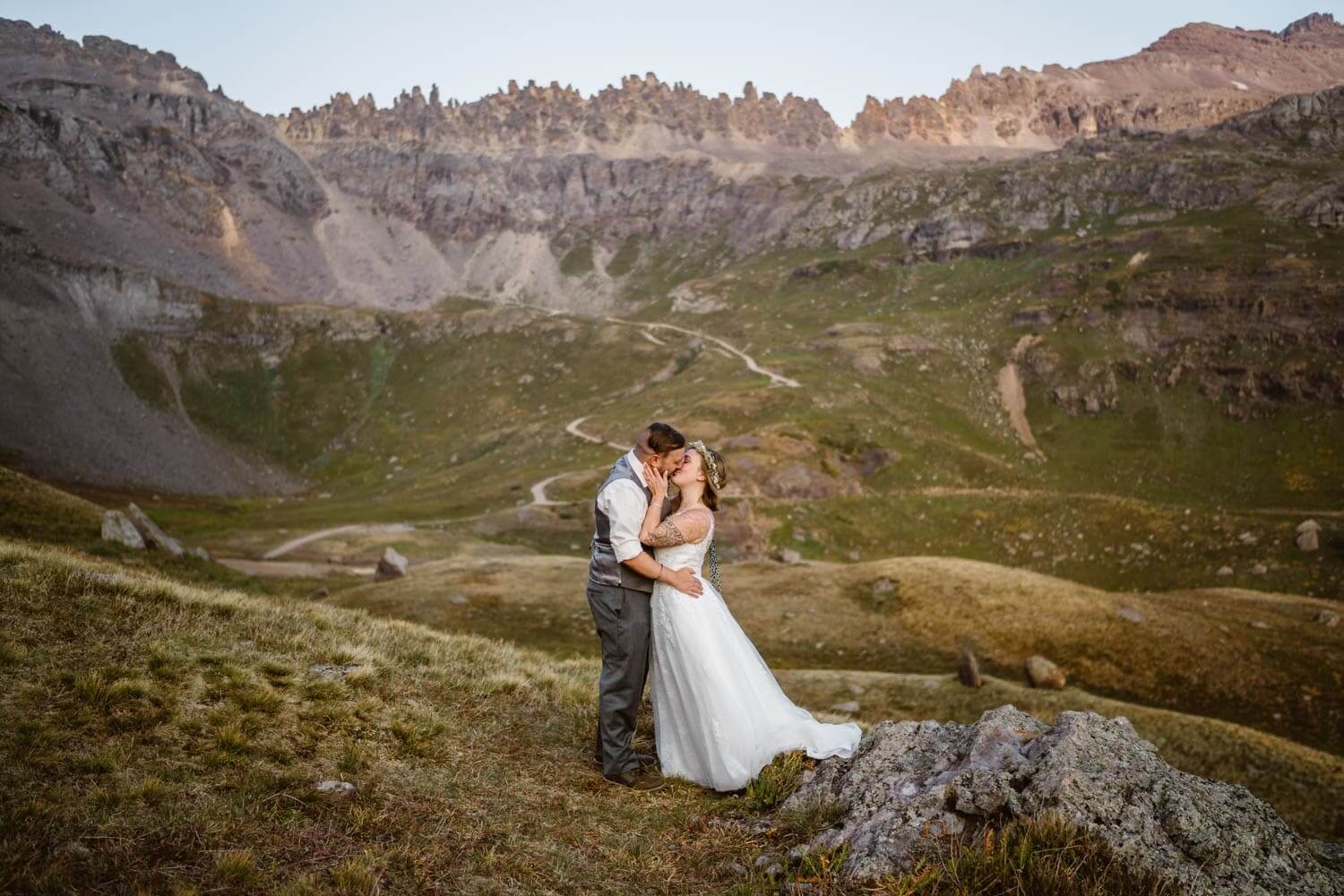 A couple sharing a kissing in their wedding attire in the mountains at their Colorado elopement.