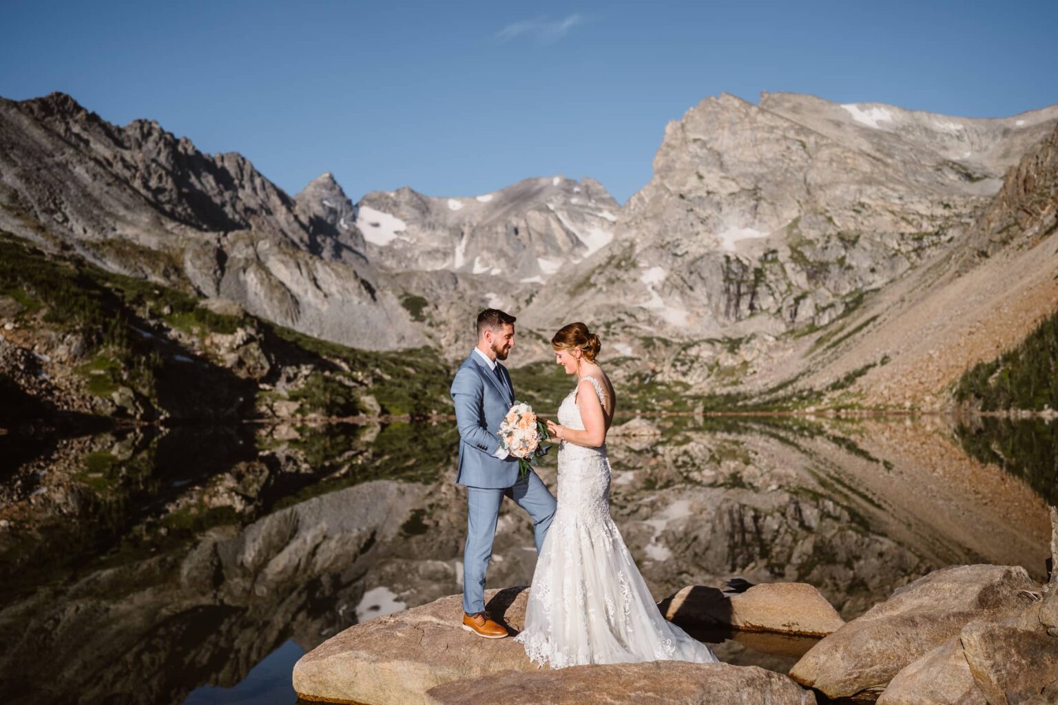 Vows and Lake Isabelle elopement Couple sharing their vows with the reflections in the water at Lake Isabelle.