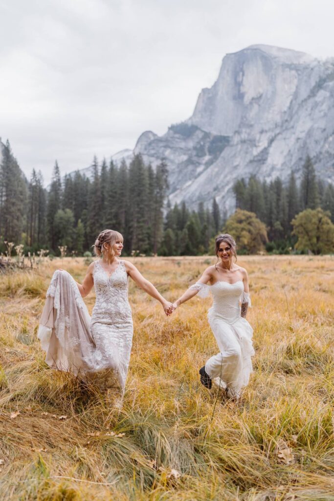 Two brides standing in a field outside of Half Dome for their Yosemite elopement.