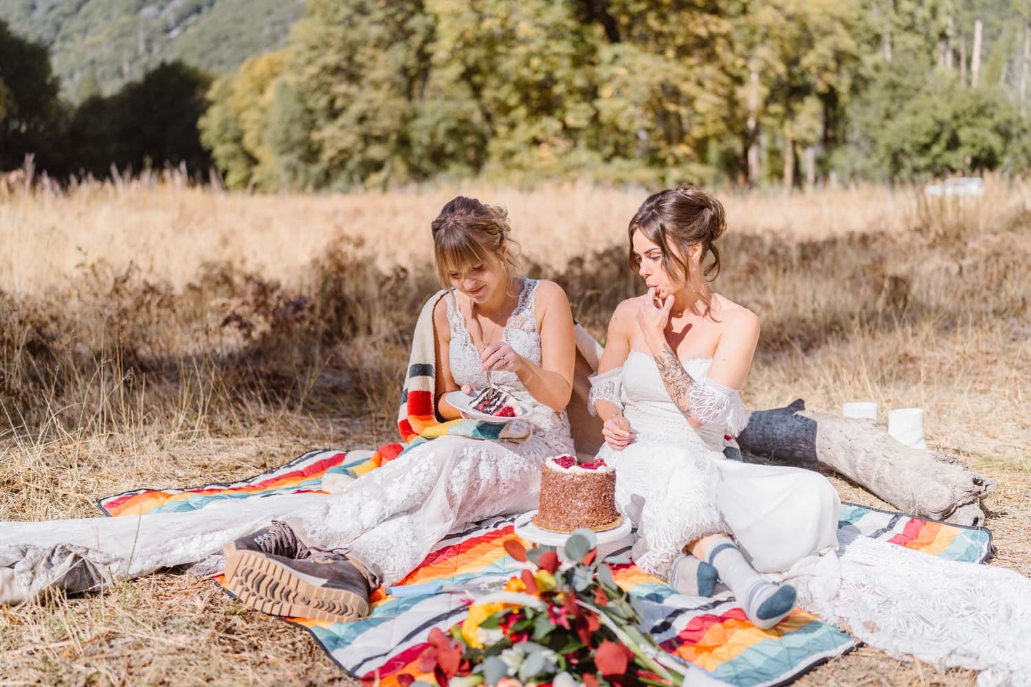 Brides sharing cake in Yosemite for their elopement.